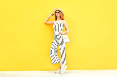 Kadın moda yuvarlak şapka renkli sarı zemin üzerine beyaz çizgili pantolon içinde poz