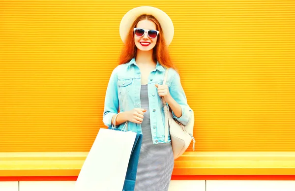 オレンジ色の背景のショッピング バッグ 麦わら帽子でクールな女の子 — ストック写真