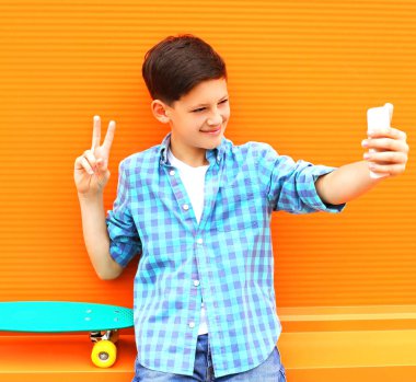 Moda serin genç çocuk alıyor resim kendi kendine portre bir smartphone cep telefonu ile 
