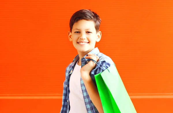 肖像画赤の背景に都市のショッピング バッグと幸せの笑みを浮かべて少年ティーンエイ ジャー — ストック写真
