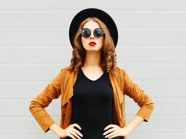 Элегантная Женщина Черной Шляпе Солнцезащитных Очках Куртке Сером Фоне — стоковое фото