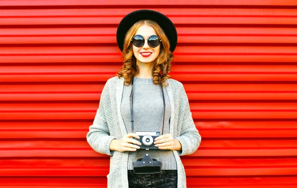 かなり秋の幸せな女の子は赤の背景にレトロなカメラを保持します — ストック写真