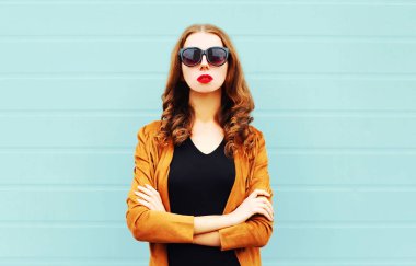 Moda portre genç kadın duvar arka plan üzerinde güneş gözlüğü