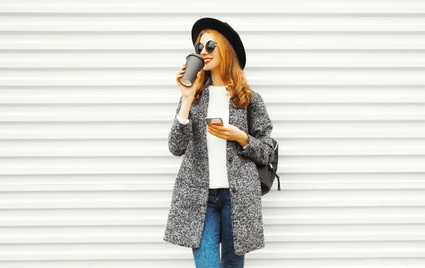 Модная Улыбающаяся Женщина Помощью Смартфона Чашкой Кофе Белом Фоне Стены — стоковое фото