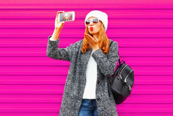 Красивая молодая женщина делает селфи на смартфоне с красными губами — стоковое фото