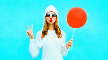 Kırmızı dudaklar esen serin kız kırmızı hava ba tutan bir hava öpücük gönderir