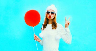 Kırmızı dudaklar üfleme portre serin kız r tutan bir hava öpücük gönderir