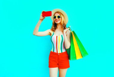 Mutlu gülümseyen kadın alışveriş ile telefonla selfie fotoğraf çekmek