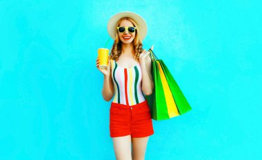 Mutlu gülümseyen kadın alışveriş çantası ile meyve suyu fincan tutan