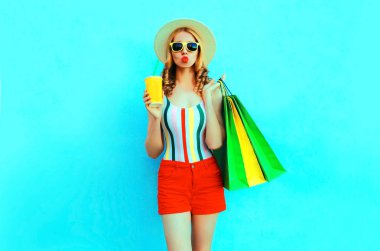 Şık kadın c alışveriş torbaları ile meyve suyu fincan tutan