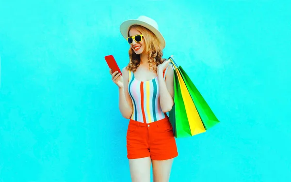 Porträtt glad leende kvinna håller telefonen med shoppingväskor i — Stockfoto