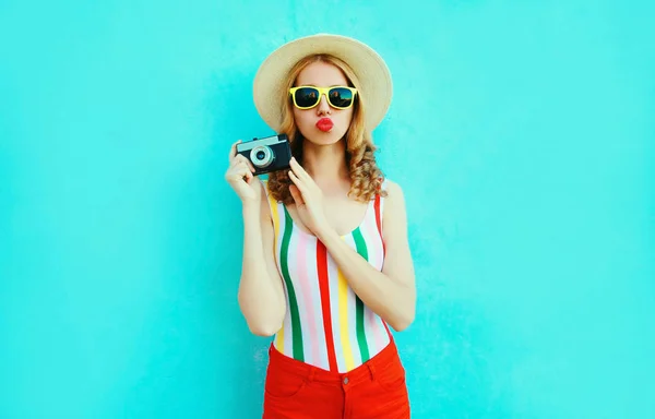 Kolorowa młoda kobieta trzyma retro kamery, dmuchanie czerwone usta wysłać — Zdjęcie stockowe