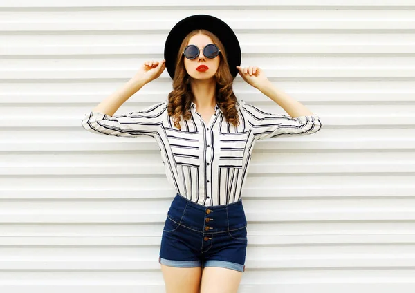 黒い丸い帽子、ショートパンツ、白いストリでスタイリッシュな若い女性モデル — ストック写真