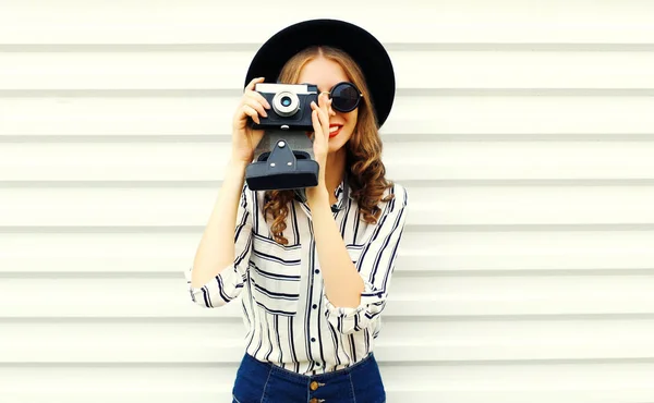 Happy smiling young woman holding vintage film camera in black r — Stock Photo, Image