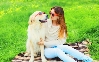 Güneş gözlüklü kadın sahibi ve Golden Retriever köpeği