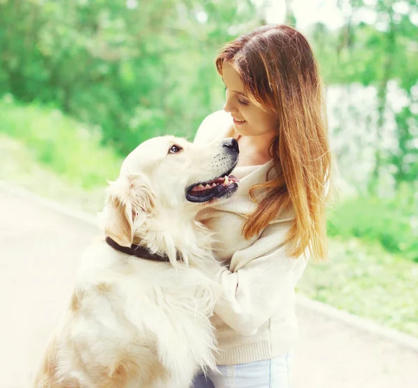 Щасливий власник жінка і Золотий ретрівер собака дивиться один на одного — стокове фото