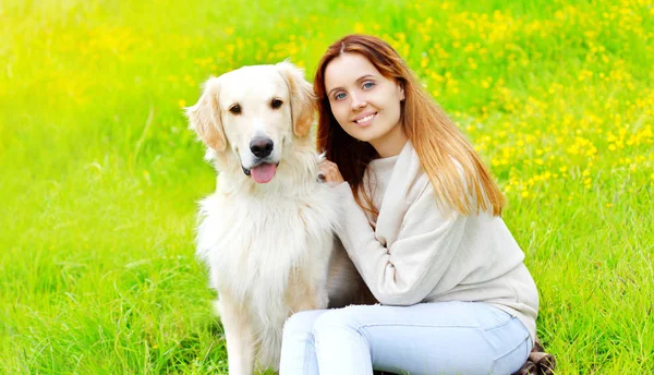 幸せな笑顔の所有者とゴールデンレトリバー犬は草の上に一緒にi — ストック写真