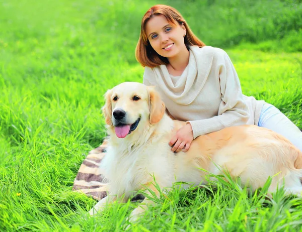 幸せな笑顔の所有者とゴールデンレトリバー犬は草の上に一緒にi — ストック写真