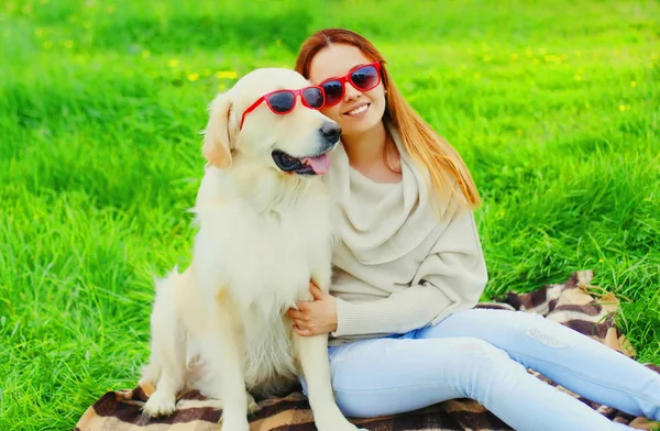Щаслива усміхнена жінка власник і золотий собака-ретривер в сонцезахисних окулярах — стокове фото