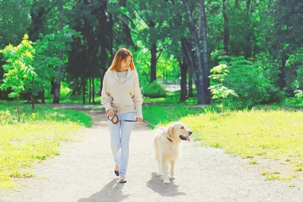 Woman owner walking with her Golden Retriever dog on leash in su — Stock Photo, Image