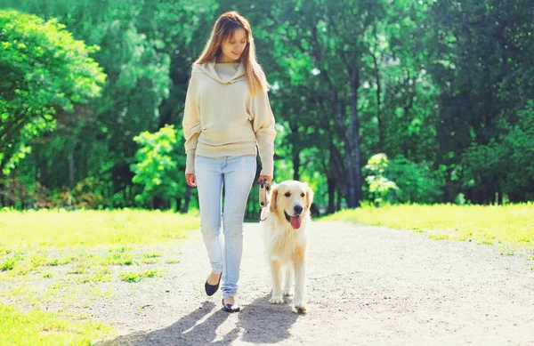Mulher proprietário andando com seu cão Golden Retriever na trela em su — Fotografia de Stock