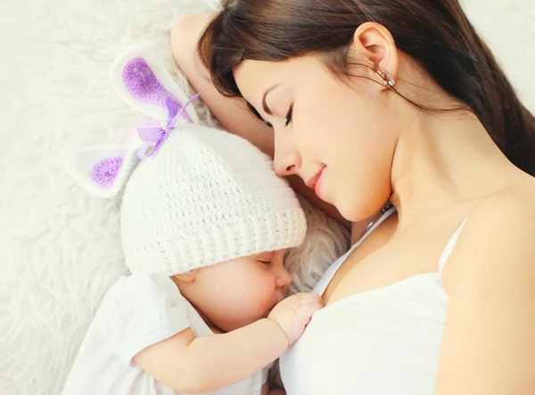 Retrato de cerca joven madre durmiendo con el bebé en la cama en casa — Foto de Stock