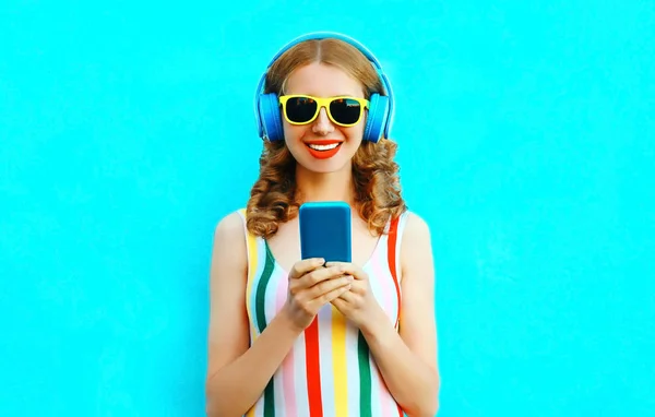 Портрет счастливой улыбающейся женщины, которая держит телефон, слушая музыку — стоковое фото