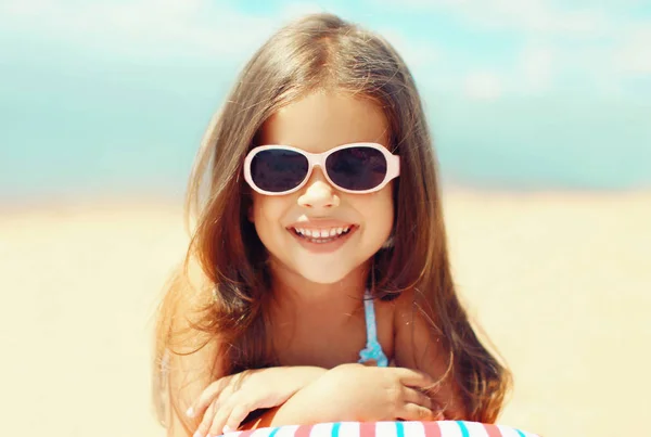 Summer close-up portrait smiling child little girl lying on sand — Stock Photo, Image