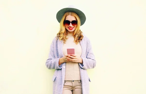 Mujer sonriente joven usando el teléfono con el pelo rizado en sombrero redondo, co —  Fotos de Stock