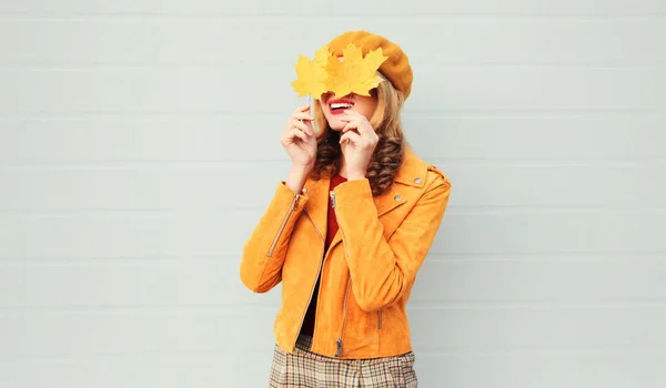 Herbststimmung! glücklich lächelnde Frau hält gelbe Ahornblätter in ihren Händen, die ihre Augen vor grauem Wandhintergrund verbergen — Stockfoto