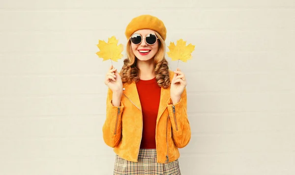 Humeur d'automne ! Élégante femme souriante heureuse avec des feuilles d'érable jaunes en béret français sur fond de mur gris — Photo