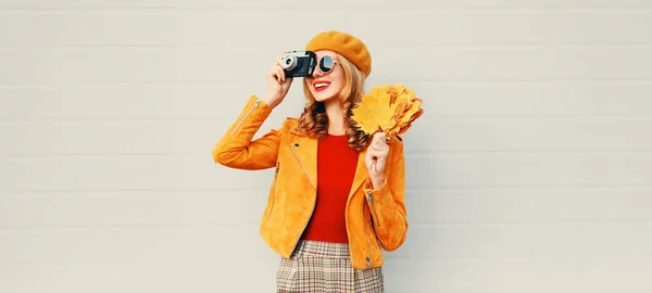 Женщина с осенью желтые кленовые листья, ретро-камера делает пикту — стоковое фото