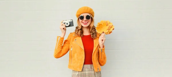 Feliz sorrindo mulher segurando outono amarelo bordo folhas, retro ca — Fotografia de Stock