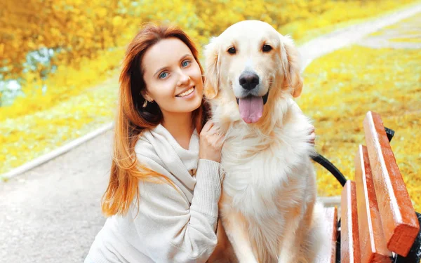Портрет счастливая улыбающаяся женщина обнимает свою золотую собаку-ретривер в городском парке — стоковое фото