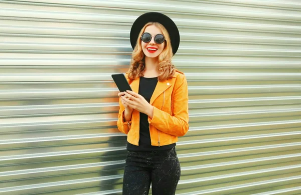 Stylish smiling woman with phone wearing yellow jacket, black ro — ストック写真