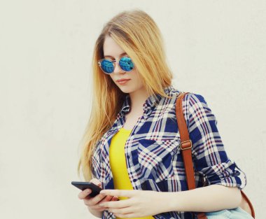 Telefona bakan sarışın genç kızın yakın portresi.