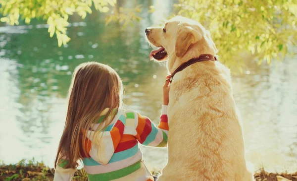 Kleines Mädchen Mit Labrador Retriever Hund Sitzt Sonnigem Sommerpark Fluss — Stockfoto