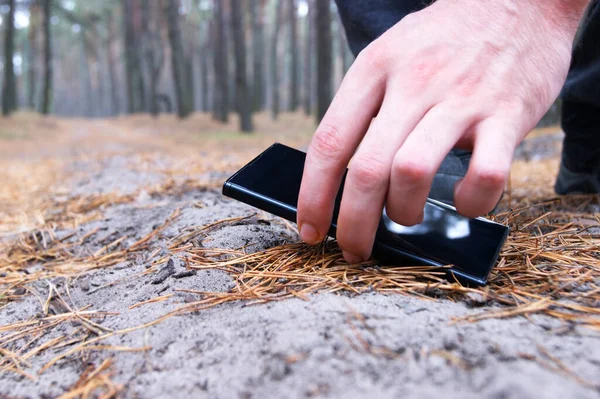 Finding a smartphone on a forest path when a man walked through the forest. Luck. Lucky.