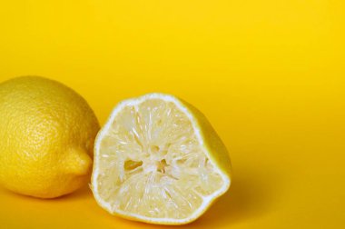 Sarı arka planda izole edilmiş taze limonlar..