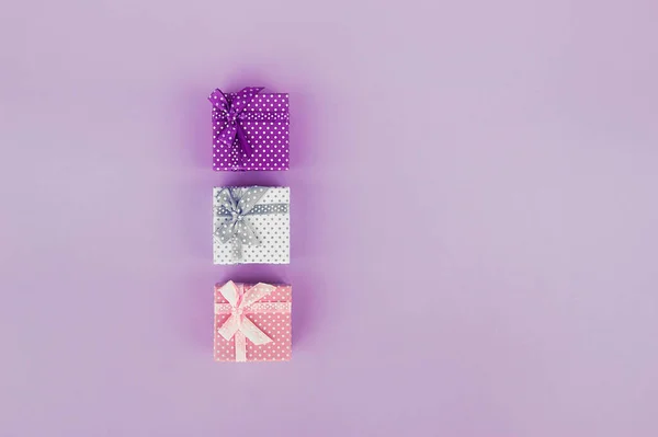 三个粉色背景的礼物礼品盒 彩色桌上的礼品装饰 顶部有复印空间 — 图库照片