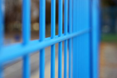 Bölgeyi çevreleyen ince metal çitler. Doğanın arka planındaki çitlere yakın çekim