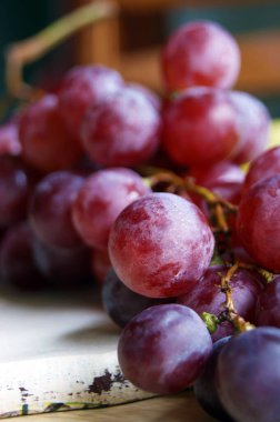 Tahta bir masada bir demet pembe üzüm. Makro. Vitaminler