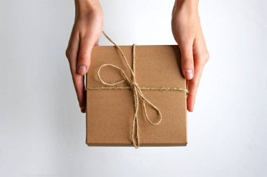 Kız elinde bir hediye kutusu tutuyor. - Sürpriz. Beyaz arkaplan.