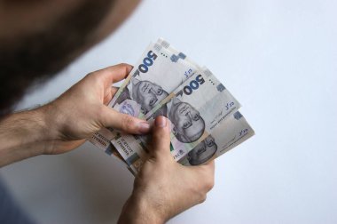 Erkek eli beyaz bir masada parasını sayar. 500 hryvnia, Ukrayna 'nın resmi ulusal para birimidir. Görüntü: Gregory Frying Pan. Ukrayna Ulusal Bankası