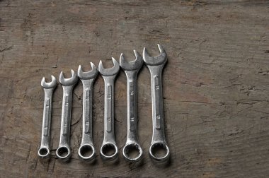 Ahşap arka planda izole edilmiş farklı boyutlarda anahtarlar. Üst görünüm