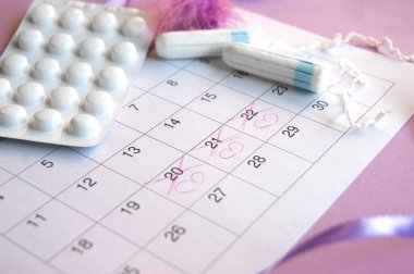 Adet takviminde regl pedi ve tampon ve leylak arkaplanlı.