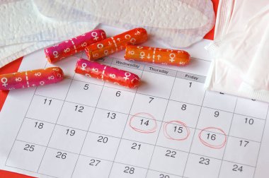 KHARKOV, UKRAINE - 17 Aralık 2019: Adet takviminde adet pedleri ve tamponlar Kotex ve kırmızı arkaplan.