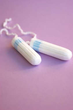 Adet takviminde regl pedi ve tampon ve leylak arkaplanlı.