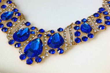 Beyaz arka planda lüks takılar. Mücevherli ticari fotoğrafçılık mücevherleri, elmaslar ve koyu mavi kristaller. Zarif tasarım için bir model