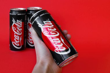 KHARKOV, UKRAINE - 23 Aralık 2019: Kırmızı kağıttan arkaplanda Coca Cola kavanozlarının yakın çekimi.